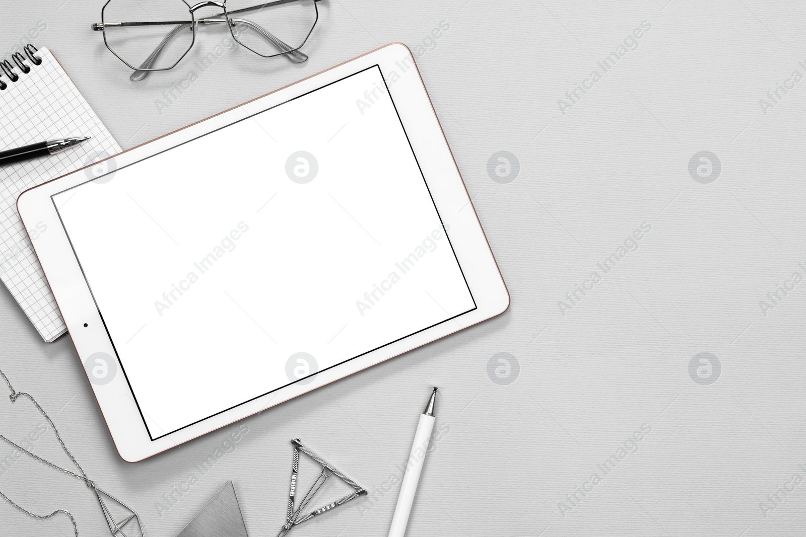 Photo of Flat lay composition with modern tablet on light grey background. Space for text