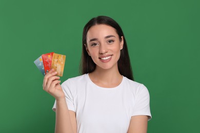 Happy woman with credit cards on green background. Debt free
