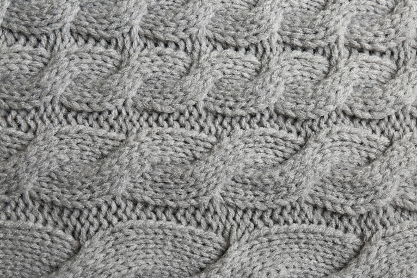 Photo of Grey knitted fabric with beautiful pattern as background, top view