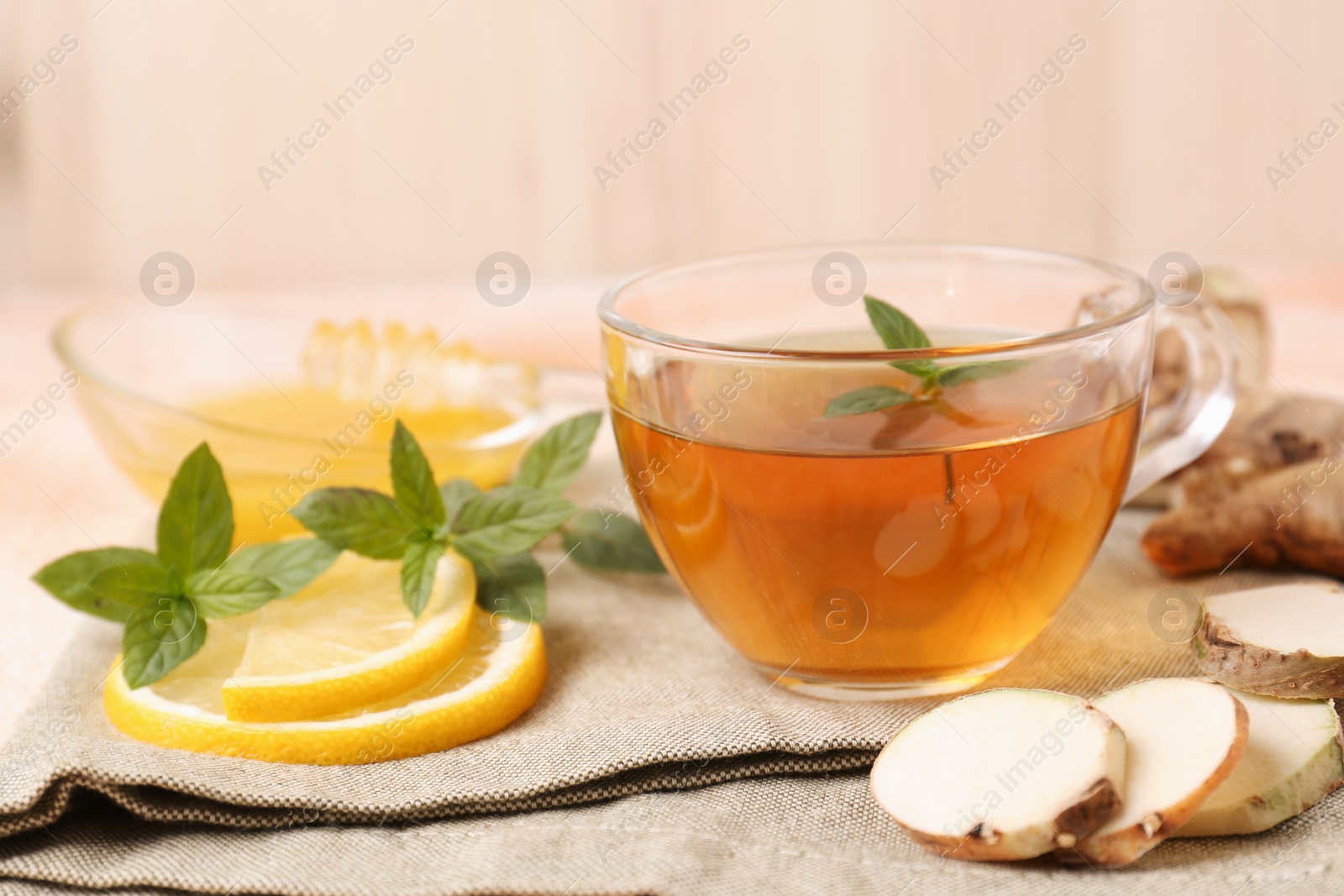 Photo of Tea with mint, honey, lemon and ginger on table