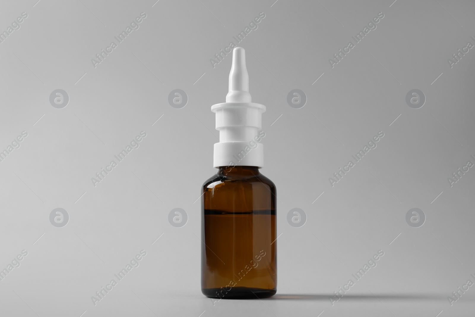 Photo of Bottle of nasal spray on grey background