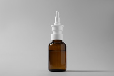 Photo of Bottle of nasal spray on grey background