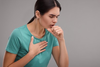 Photo of Woman coughing on grey background, space for text. Cold symptoms