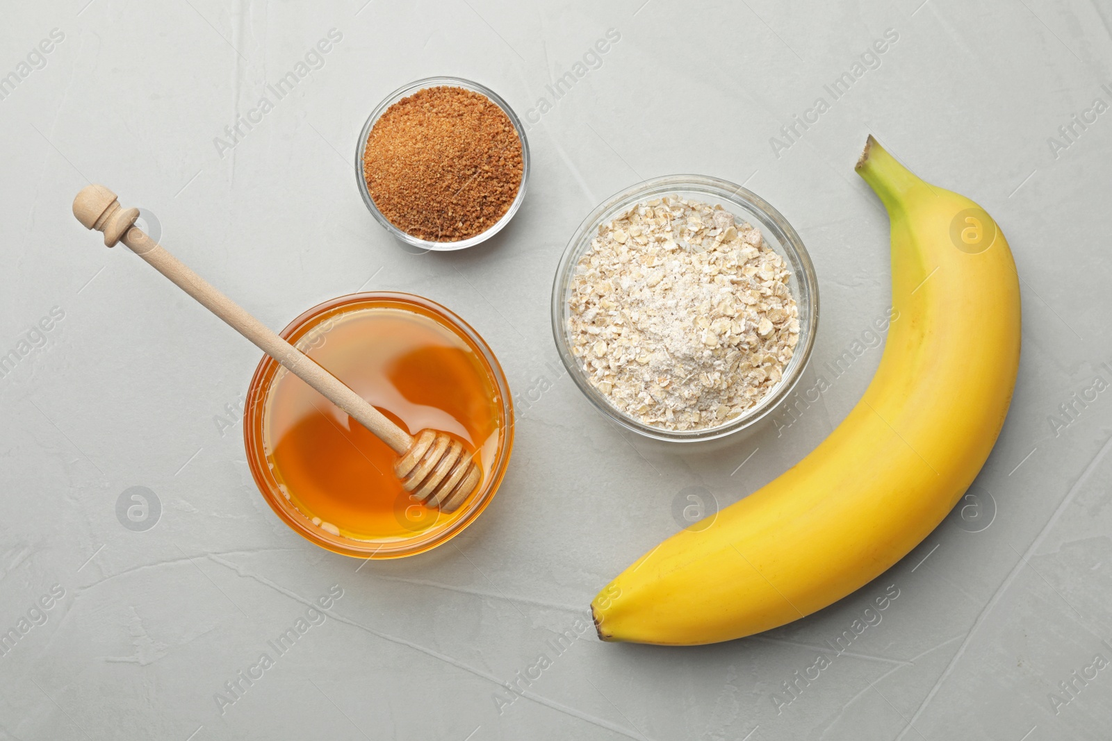 Photo of Different ingredients for handmade face mask on grey stone background, flat lay