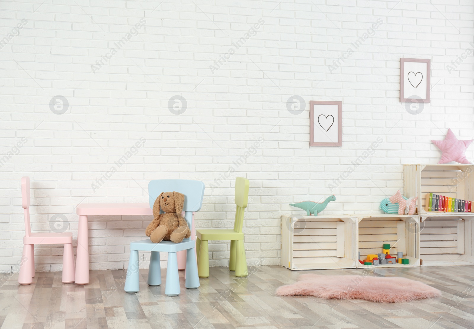 Photo of Cozy kids room interior with table, chairs and toys