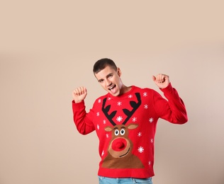 Photo of Portrait of happy man in Christmas sweater on beige background