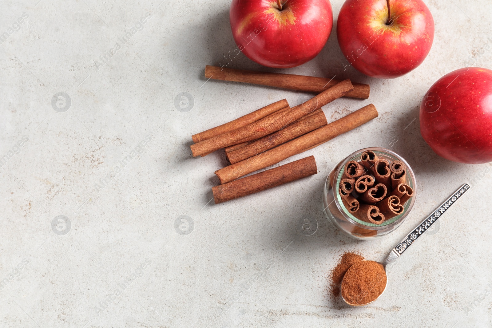 Photo of Fresh apples with cinnamon sticks and powder on table, top view