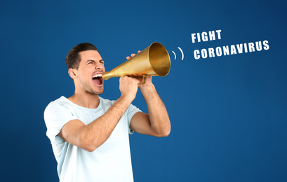 Image of Handsome man with megaphone on blue background. Fighting with coronavirus