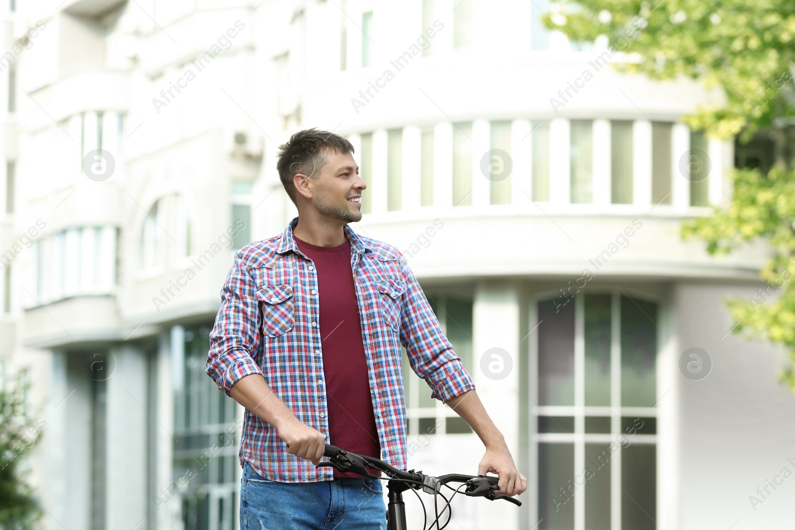 Photo of Handsome man with modern bicycle on city street