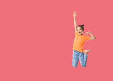 Image of Cute girl jumping on pale red background, space for text