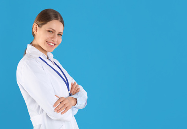 Photo of Portrait of young doctor on blue background, space for text