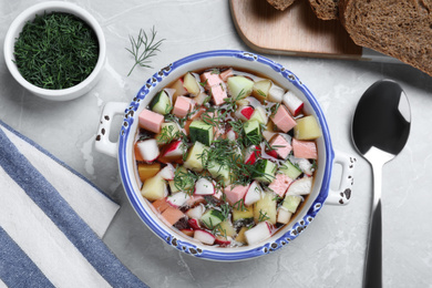 Delicious cold okroshka with kvass served on grey table, flat lay. Traditional Russian summer soup