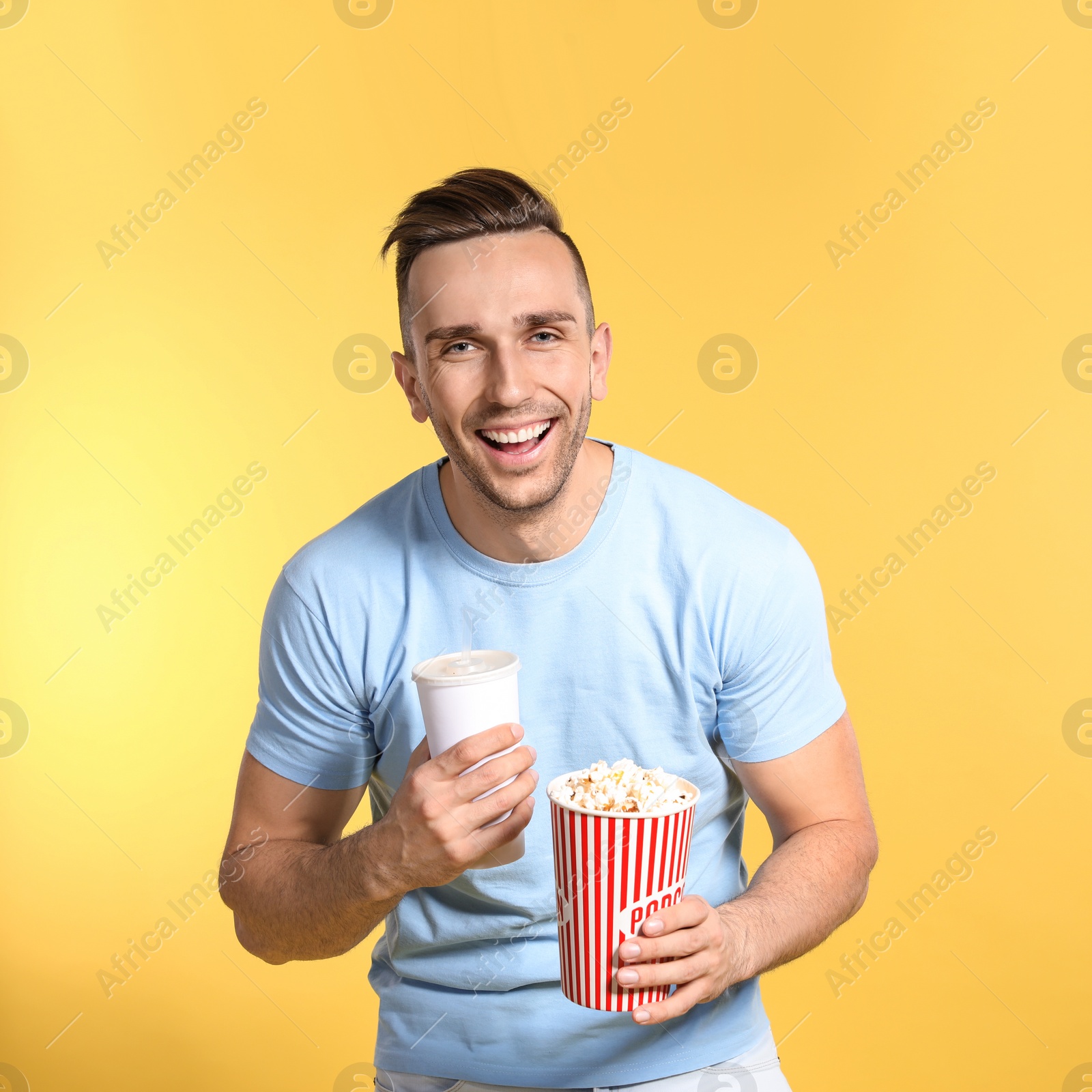 Photo of Man with popcorn and beverage during cinema show on color background