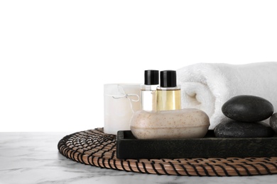 Photo of Mat with towel and spa supplies on marble table against white background