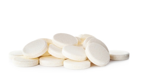 Photo of Pile of vitamin pills on white background