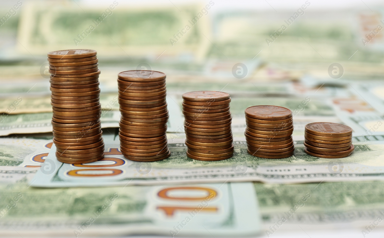 Photo of Stacks of metal coins on dollar banknotes