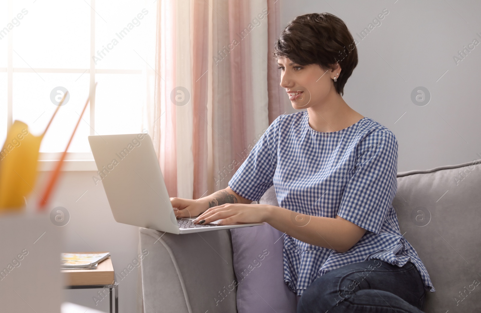 Photo of Young woman working with laptop at home