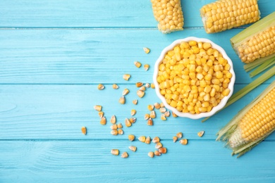 Flat lay composition with corn kernels on blue wooden background. Space for text