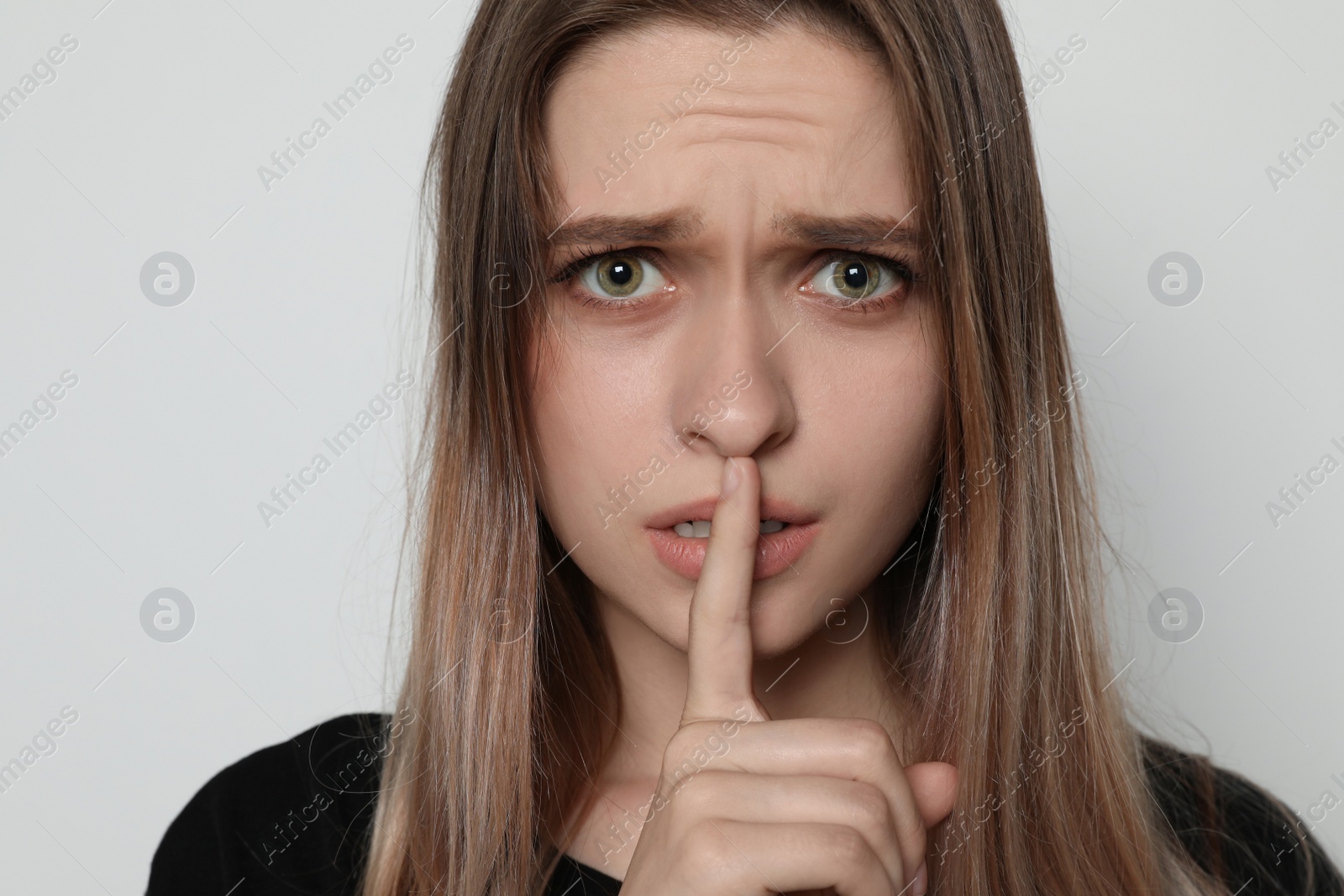 Photo of Abused woman making silent gesture on light background. Stop violence