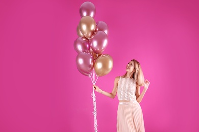 Photo of Young woman with air balloons on color background