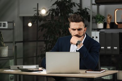 Photo of Man working on laptop at table in office, space for text