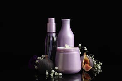 Photo of Set of hair cosmetic products, flowers and figs on  black background