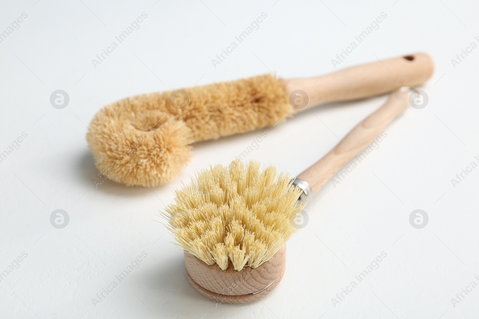 Photo of Cleaning brushes for dish washing on white background, closeup