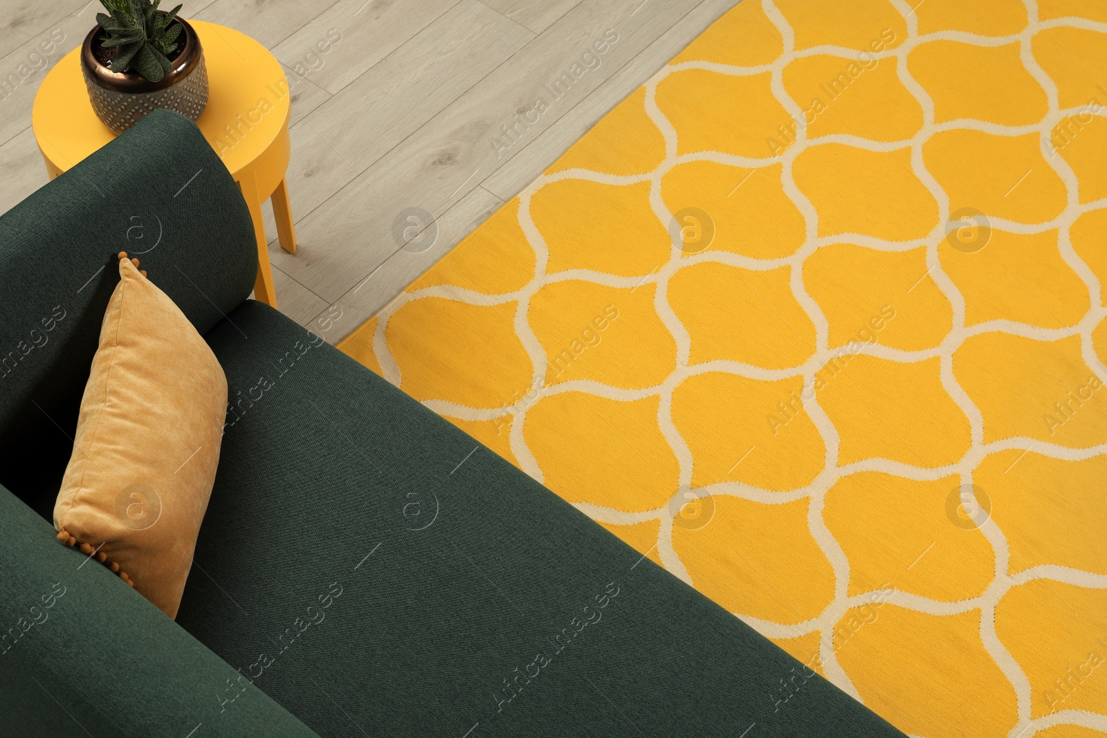 Photo of Yellow carpet with geometric pattern on wooden floor in living room