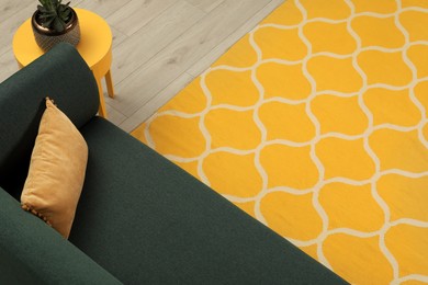 Yellow carpet with geometric pattern on wooden floor in living room
