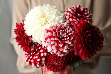 Photo of Woman with bouquet of beautiful dahlia flowers, closeup