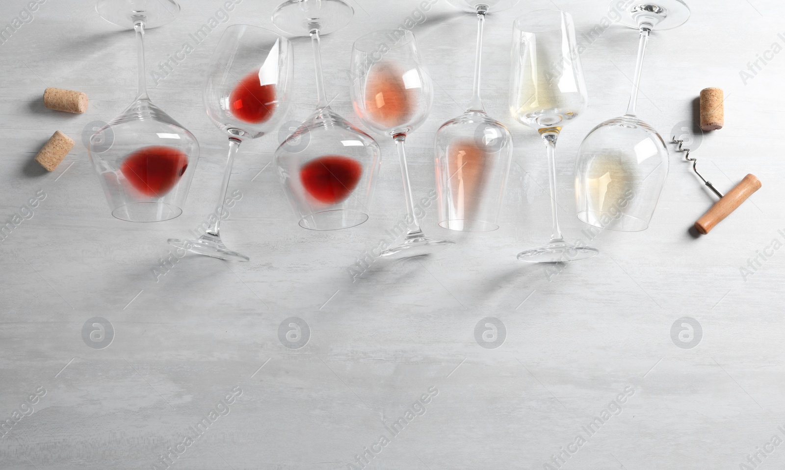 Photo of Different glasses with wine on light background, flat lay. Space for text