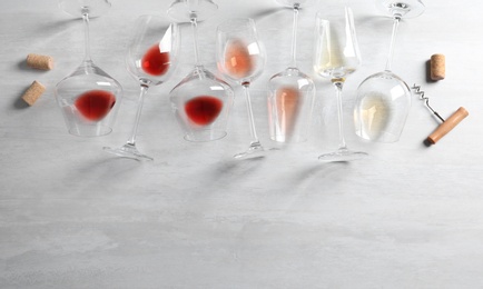 Photo of Different glasses with wine on light background, flat lay. Space for text