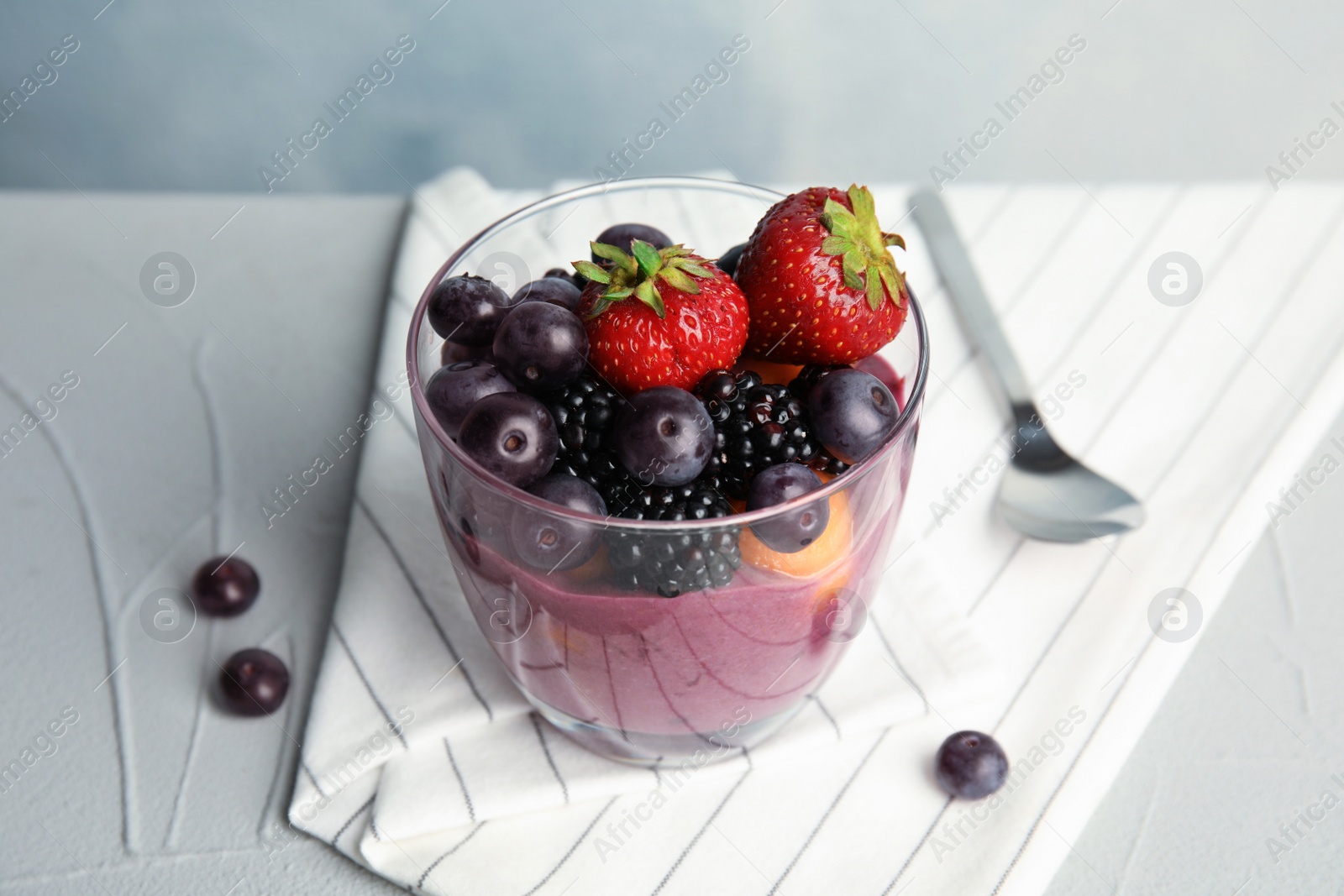 Photo of Glass with tasty acai smoothie on gray table