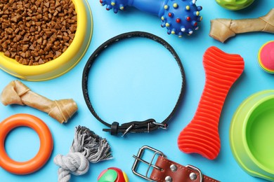 Photo of Flat lay composition with dog collar, toys and food on light blue background