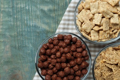 Photo of Different delicious breakfast cereals on blue wooden table, flat lay. Space for text