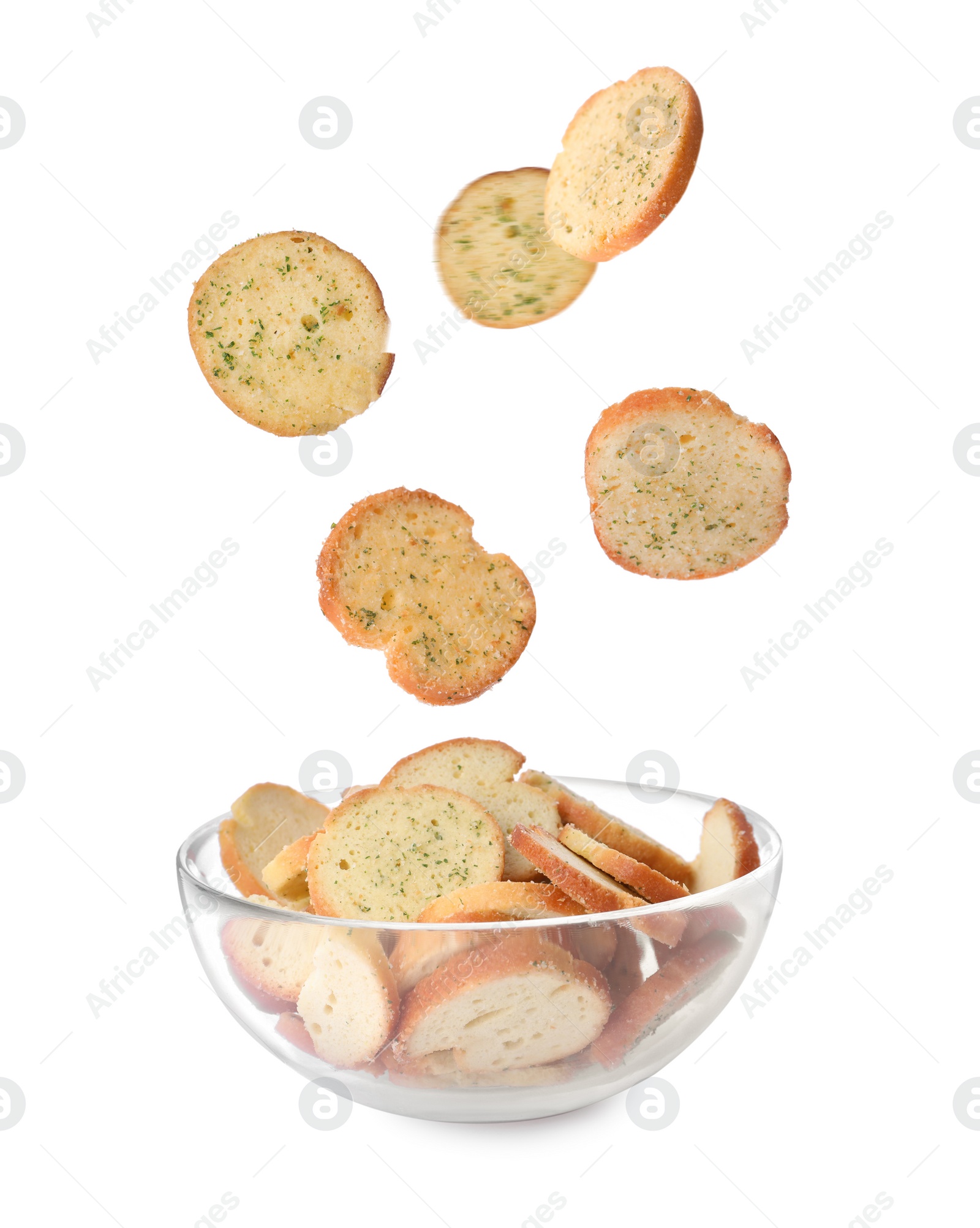 Image of Delicious crispy rusks falling into bowl on white background