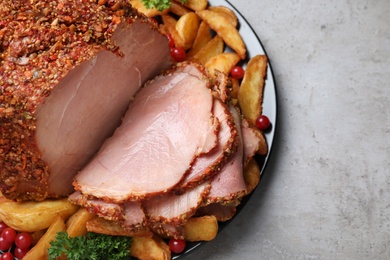 Plate with delicious ham and potatoes on grey table, top view