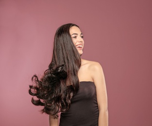 Portrait of beautiful model with gorgeous curly hair on color background