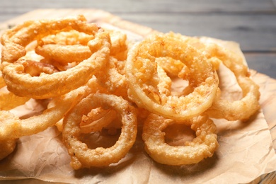 Photo of Homemade crunchy fried onion rings on cutting board, closeup