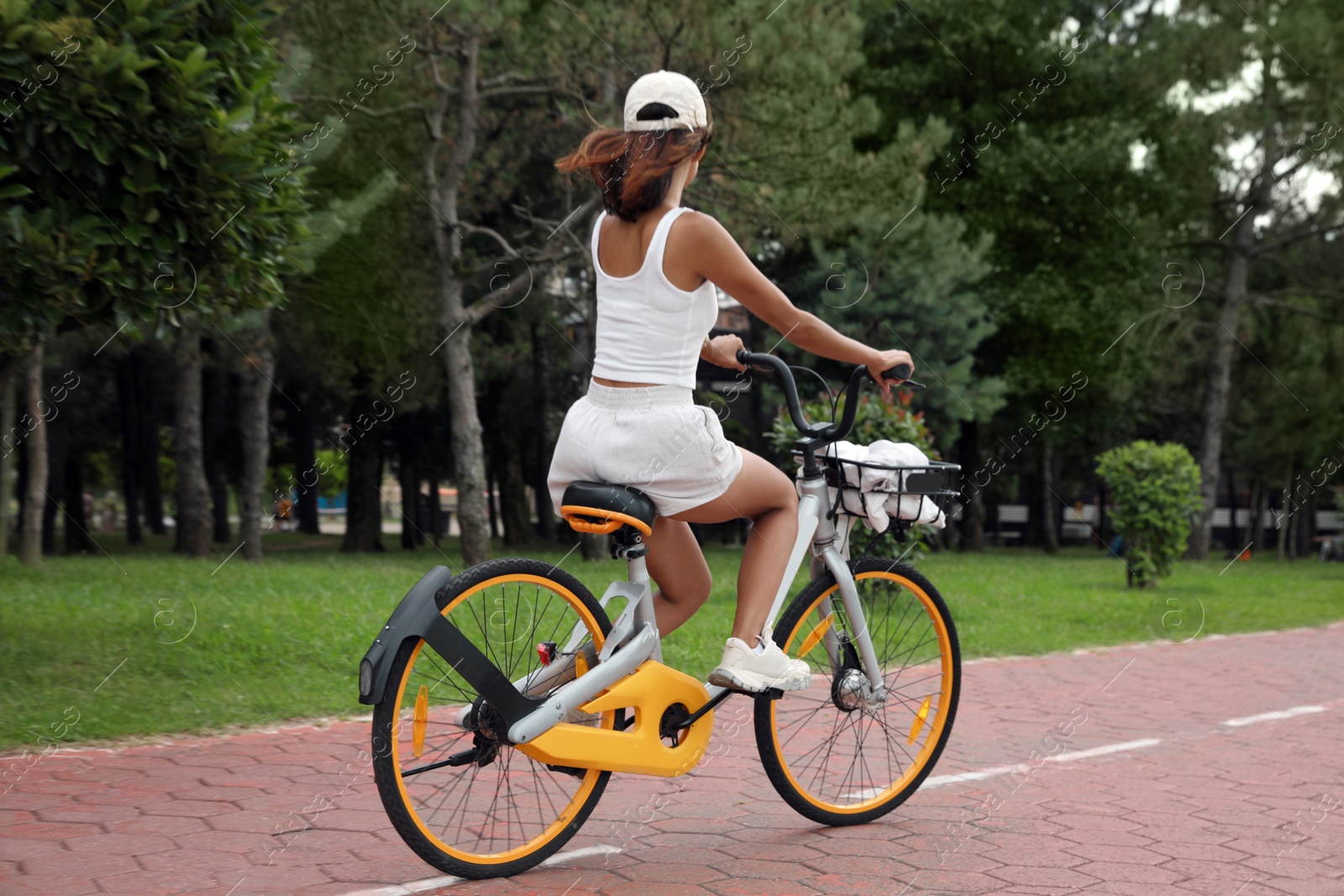 Photo of Beautiful young woman riding bicycle on lane outdoors