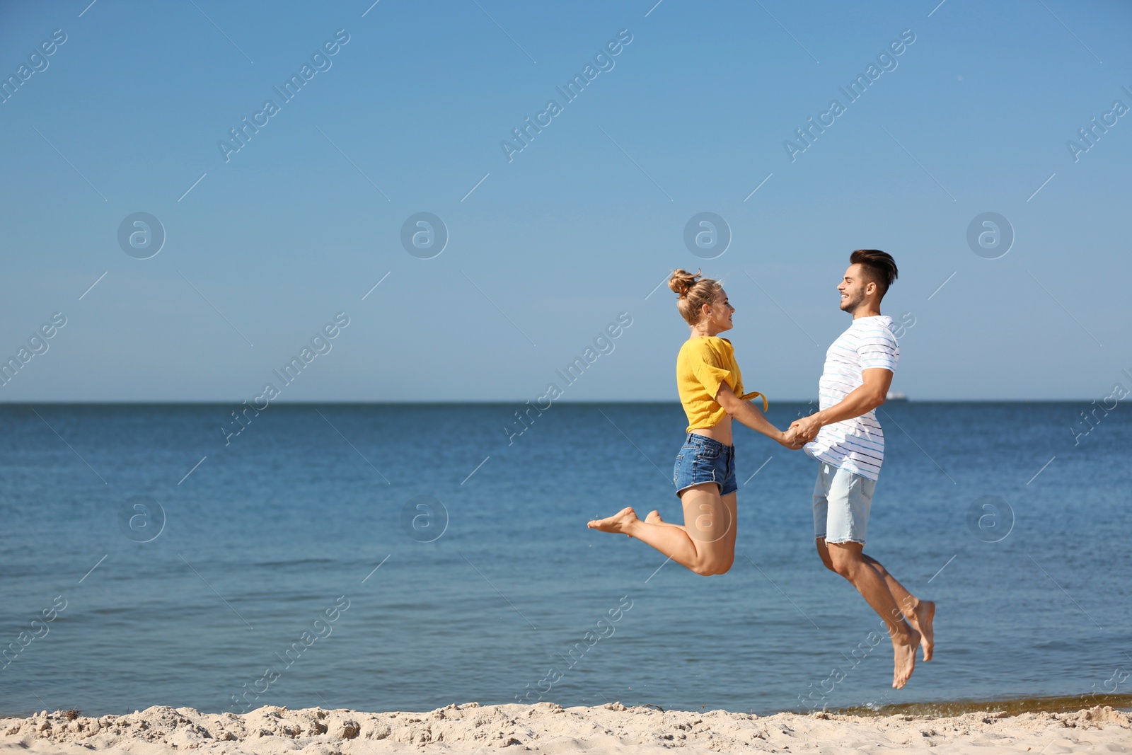 Photo of Happy young couple having fun at beach on sunny day