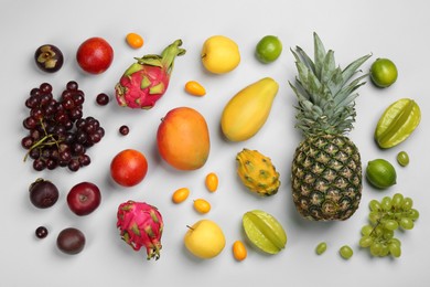 Photo of Many different delicious exotic fruits on light background, flat lay