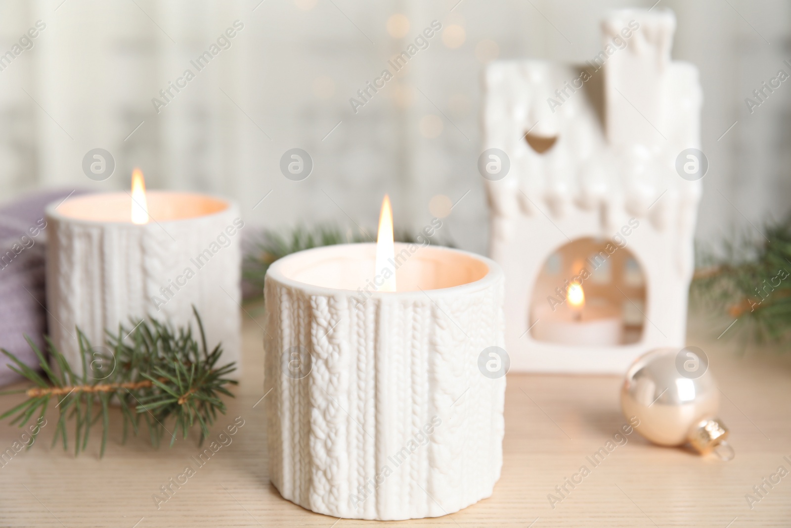 Photo of Composition with candle in ornate holder on wooden table. Christmas decoration