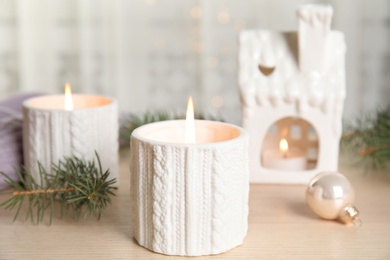 Photo of Composition with candle in ornate holder on wooden table. Christmas decoration