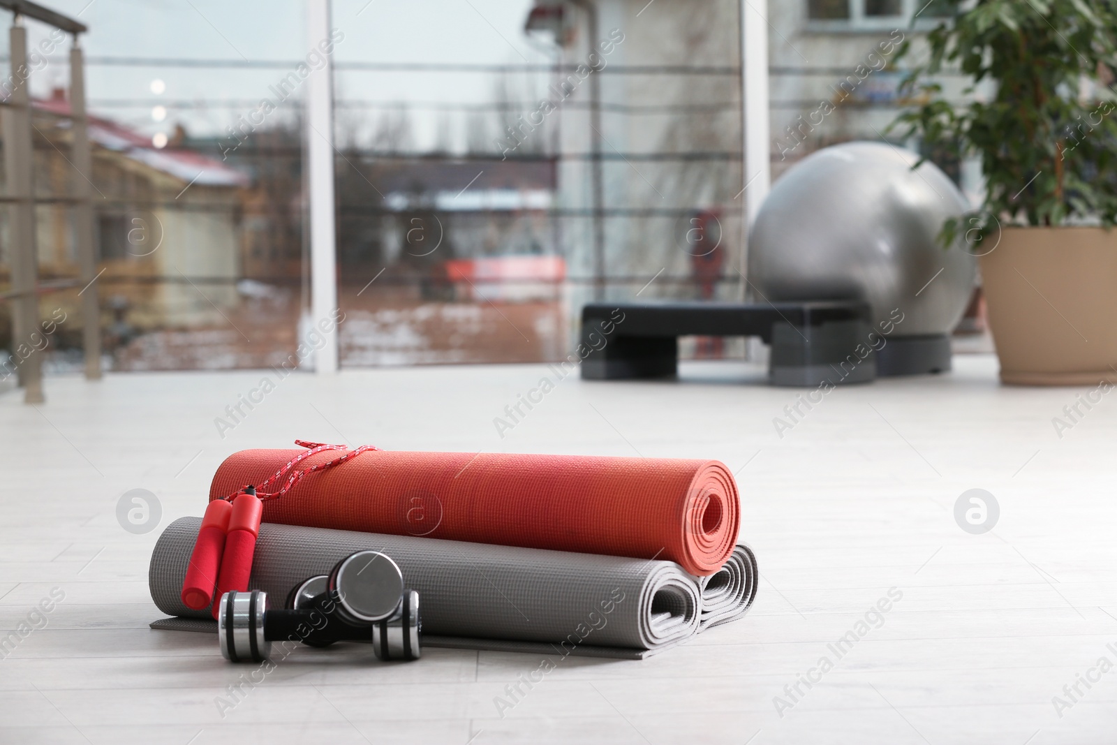 Photo of Set of fitness equipment of floor indoors. Space for text