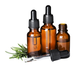 Different bottles of essential oils and rosemary on white background