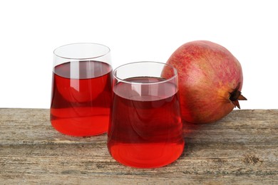 Photo of Refreshing pomegranate juice in glasses and fruit on wooden table against white background