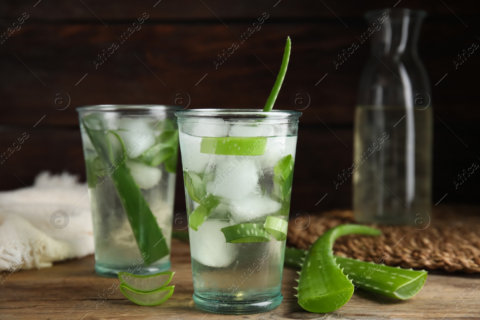 Photo of Fresh aloe drink with ice cubes on wooden table