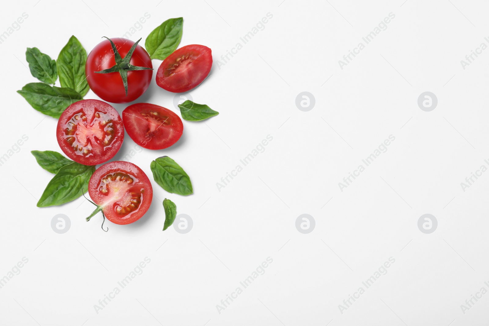 Photo of Fresh basil leaves and tomatoes on white background, flat lay. Space for text