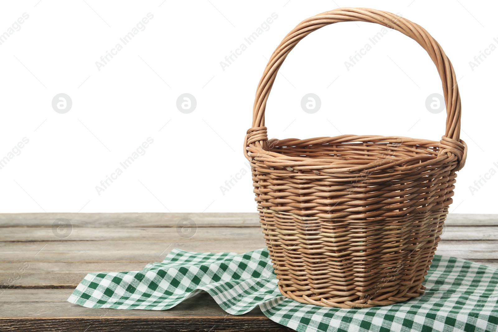 Photo of Empty wicker basket and cloth on wooden table against white background, space for text. Easter holiday